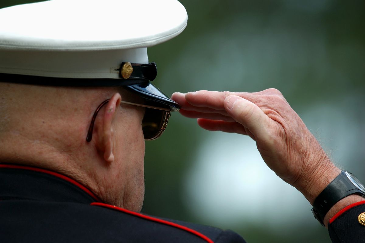 A Marine in dress uniform offering a salute